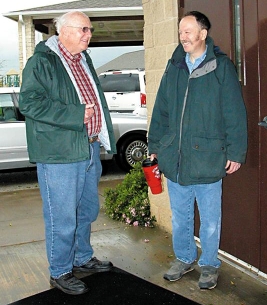 At Southside Church of Christ, former minister Ray Crook and his son, Stephen, stand outside the fellowship center ready to assist any displaced flood victims.